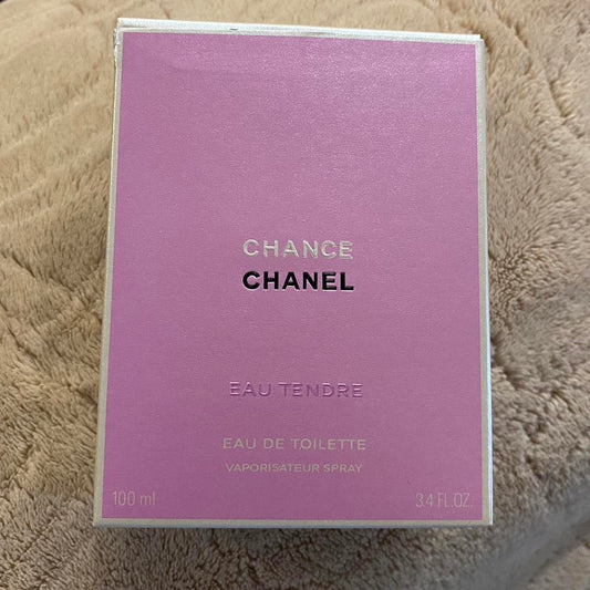 Chanel Change Eau Tendre Eau de Toilette spray box in a light purple/lavender color, resting on a beige textured blanket background.